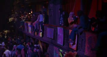 Movie still from “Coogan's Bluff” (1968), directed by Don Siegel – A group of people sitting on top of a wooden platform; Extreme Wide shot, High angle