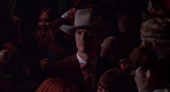 Movie still from “Coogan's Bluff” (1968), directed by Don Siegel – A man wearing a cowboy hat in a crowd of onlookers; Close Up shot, Low angle