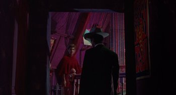 Movie still from “Coogan's Bluff” (1968), directed by Don Siegel – A man in a cowboy hat and a woman in a red dress; Medium shot, Low angle