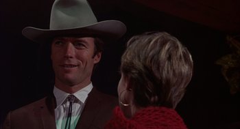 Movie still from “Coogan's Bluff” (1968), directed by Don Siegel – A man in a cowboy hat talking to a woman in a red sweater; Close Up shot, Over the shoulder angle