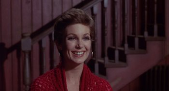 Movie still from “Coogan's Bluff” (1968), directed by Don Siegel – A woman in a red sweater smiling for the camera; Close Up shot, Low angle