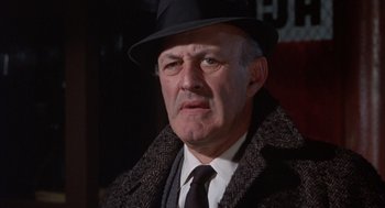Movie still from “Coogan's Bluff” (1968), directed by Don Siegel – An older man wearing a black hat and a black tie; Close Up shot, Low angle