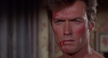 Movie still from “Coogan's Bluff” (1968), directed by Don Siegel – A man with blood on his face; Close Up shot, Over the shoulder angle