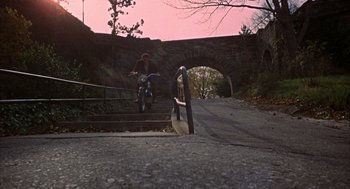 Movie still from “Coogan's Bluff” (1968), directed by Don Siegel – A man riding a motorcycle down the side of a bridge; Extreme Wide shot, High angle