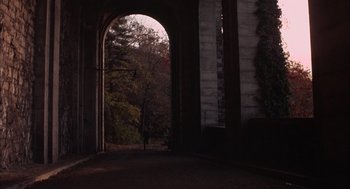 Movie still from “Coogan's Bluff” (1968), directed by Don Siegel – An archway leading to a park with trees in the background; Extreme Wide shot, High angle