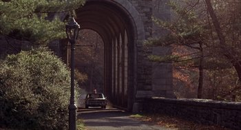 Movie still from “Coogan's Bluff” (1968), directed by Don Siegel – A car drives under an arched stone bridge; Extreme Wide shot, High angle