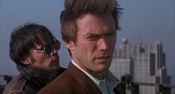 Movie still from “Coogan's Bluff” (1968), directed by Don Siegel – A person wearing a suit and sunglasses; Close Up shot, Low angle