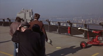 Movie still from “Coogan's Bluff” (1968), directed by Don Siegel – Two people are walking on the edge of a building; Wide shot, Over the shoulder angle