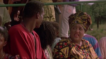 Movie still from “Cool Runnings” (1993), directed by Jon Turteltaub – A group of people sitting on top of a bus; Close Up shot, Over the shoulder angle