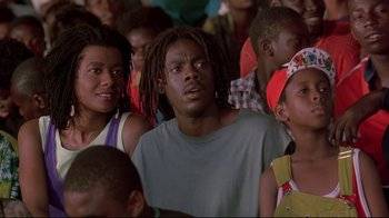 Movie still from “Cool Runnings” (1993), directed by Jon Turteltaub – A group of people standing around each other in a room; Close Up shot, Low angle