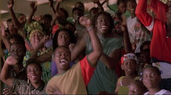 Movie still from “Cool Runnings” (1993), directed by Jon Turteltaub – A group of young men and women are watching a game; Medium shot, Low angle