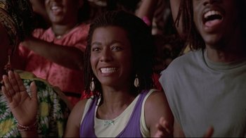 Movie still from “Cool Runnings” (1993), directed by Jon Turteltaub – A person with dreadlocks smiling; Close Up shot, Low angle