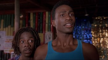 Movie still from “Cool Runnings” (1993), directed by Jon Turteltaub – Two people standing next to each other in a room; Close Up shot, Low angle