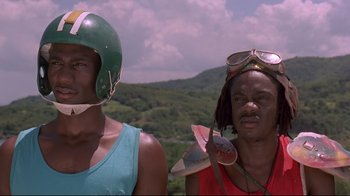 Movie still from “Cool Runnings” (1993), directed by Jon Turteltaub – Two men wearing helmets are standing next to each other; Close Up shot, Low angle