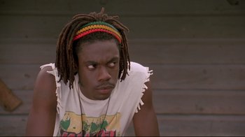 Movie still from “Cool Runnings” (1993), directed by Jon Turteltaub – A man with dreadlocks is looking at the camera; Close Up shot, Low angle