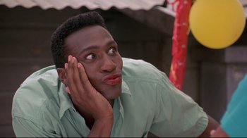 Movie still from “Cool Runnings” (1993), directed by Jon Turteltaub – A man with his hand on his face looking to his left; Close Up shot, High angle