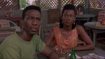 Movie still from “Cool Runnings” (1993), directed by Jon Turteltaub – A man and a woman sitting next to each other at a table; Close Up shot, High angle