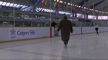 Movie still from “Cool Runnings” (1993), directed by Jon Turteltaub – A man is walking on the ice with a skate board; Extreme Wide shot, High angle