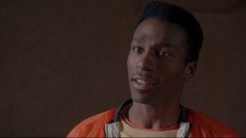 Movie still from “Cool Runnings” (1993), directed by Jon Turteltaub – A person wearing an orange jacket; Close Up shot, Low angle