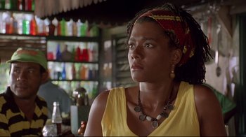 Movie still from “Cool Runnings” (1993), directed by Jon Turteltaub – A woman wearing a head scarf and a yellow shirt; Close Up shot, Low angle