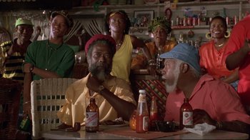 Movie still from “Cool Runnings” (1993), directed by Jon Turteltaub – A group of people sitting at a table with bottles of beer; Medium shot, Low angle