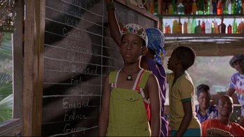 Movie still from “Cool Runnings” (1993), directed by Jon Turteltaub – A group of people standing next to each other in front of a chalkboard; Medium shot, Over the shoulder angle