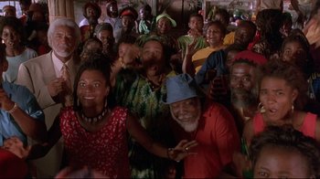 Movie still from “Cool Runnings” (1993), directed by Jon Turteltaub – A group of people that are posing for a picture; Medium shot, High angle