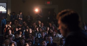 Movie still from “The Front Runner” (2018), directed by Jason Reitman – A crowd of people sitting in a room watching a man speak; Wide shot, High angle