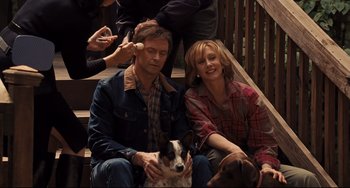 Movie still from “The Front Runner” (2018), directed by Jason Reitman – A man and a woman sitting next to a dog on steps; Medium shot, High angle