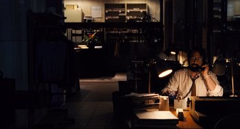 Movie still from “The Front Runner” (2018), directed by Jason Reitman – A man sitting at a table in a dark room; Wide shot, High angle