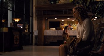 Movie still from “The Front Runner” (2018), directed by Jason Reitman – A woman sitting on a chair in a lobby; Wide shot, Over the shoulder angle