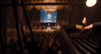 Movie still from “The Front Runner” (2018), directed by Jason Reitman – A crowd of people sitting in front of a large screen; Wide shot, High angle