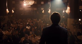 Movie still from “The Front Runner” (2018), directed by Jason Reitman – A man standing in front of an audience in a room; Wide shot, Over the shoulder angle