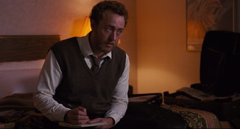 Movie still from “The Front Runner” (2018), directed by Jason Reitman – A man sitting in a room writing on a piece of paper; Medium shot, Over the shoulder angle