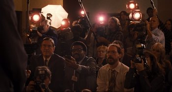 Movie still from “The Front Runner” (2018), directed by Jason Reitman – A group of people sitting in a room with microphones; Wide shot, High angle