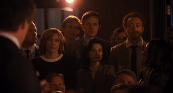 Movie still from “The Front Runner” (2018), directed by Jason Reitman – A group of people sitting in a dark room; Medium shot, Over the shoulder angle