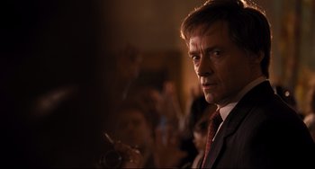 Movie still from “The Front Runner” (2018), directed by Jason Reitman – A man in a suit and tie smoking a cigarette in front of a crowd; Close Up shot, Low angle
