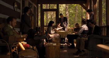 Movie still from “The Front Runner” (2018), directed by Jason Reitman – A group of people sitting around a table in front of trees; Wide shot, High angle