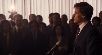Movie still from “The Front Runner” (2018), directed by Jason Reitman – A group of people standing in front of a microphone; Medium shot, Over the shoulder angle