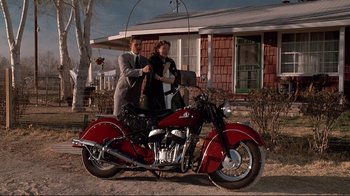 Movie still from “Cool World” (1992), directed by Ralph Bakshi – A man and a woman standing next to a red motorcycle; Wide shot, Low angle