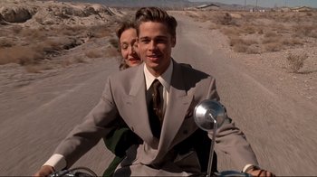 Movie still from “Cool World” (1992), directed by Ralph Bakshi – A man and a woman riding a motorcycle down a dirt road; Medium shot, Low angle