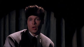 Movie still from “Cool World” (1992), directed by Ralph Bakshi – A man in a suit and tie with a hair piece; Close Up shot, Over the shoulder angle