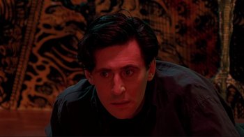 Movie still from “Cool World” (1992), directed by Ralph Bakshi – A person sitting in front of a wall; Close Up shot, Low angle