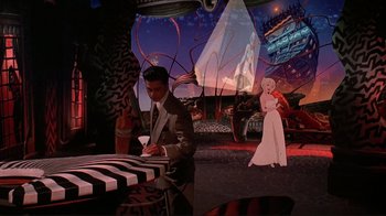 Movie still from “Cool World” (1992), directed by Ralph Bakshi – A man and a woman are standing at a table; Wide shot, High angle