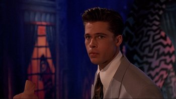 Movie still from “Cool World” (1992), directed by Ralph Bakshi – A man in a suit and tie looking at the camera; Close Up shot, Over the shoulder angle