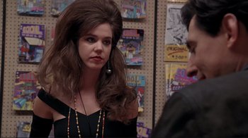 Movie still from “Cool World” (1992), directed by Ralph Bakshi – A woman with long brown hair wearing a black dress; Close Up shot, Over the shoulder angle