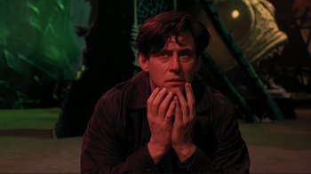 Movie still from “Cool World” (1992), directed by Ralph Bakshi – A man sitting on the ground with his hands on his face; Close Up shot, Low angle