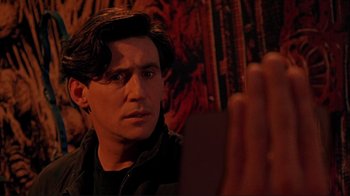 Movie still from “Cool World” (1992), directed by Ralph Bakshi – A person looking at a camera; Close Up shot, Over the shoulder angle