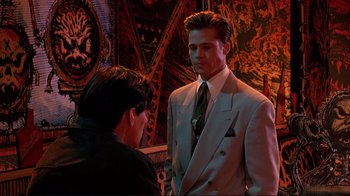 Movie still from “Cool World” (1992), directed by Ralph Bakshi – A man in a suit and tie talking to another man in a suit and tie; Medium shot, Over the shoulder angle