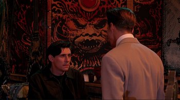 Movie still from “Cool World” (1992), directed by Ralph Bakshi – Two men in a room talking to each other; Medium shot, Over the shoulder angle